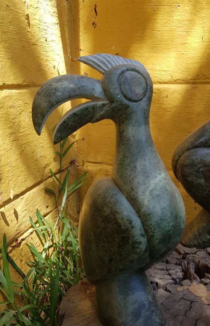 Intricately Carved Abstract Bird Sculptures in a Serene Outdoor Setting