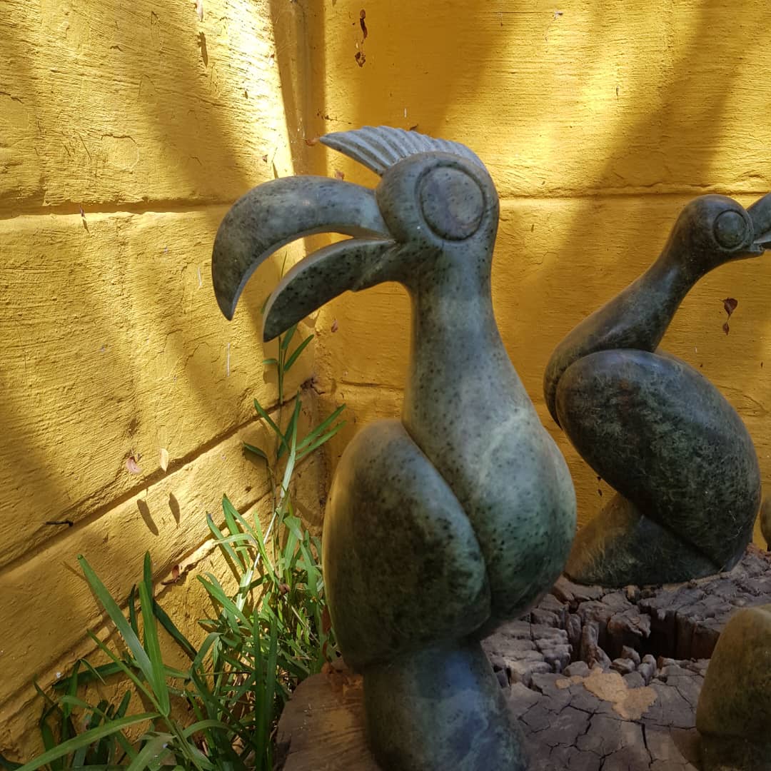 Intricately Carved Abstract Bird Sculptures in a Serene Outdoor Setting